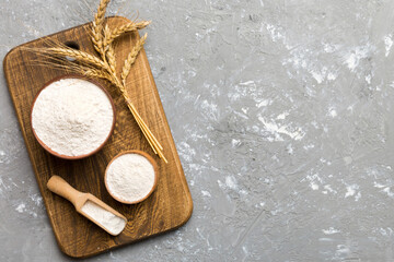 Flat lay of Wheat flour in wooden bowl with wheat spikelets on colored background. world wheat...
