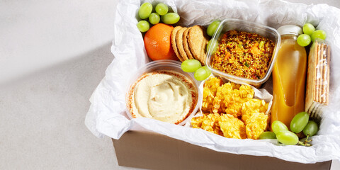 Ready prepared brunch box with quinoa salad, gluten free nuggets and fresh smoothie, top view