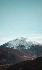 Snow-Capped Mountain Peak Against a Clear Blue Sky, Dramatic Alpine Landscape