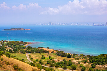 Viewpoint photo taken from the viewpoint on Koh Larn, showing the nature on the island and the crystal clear blue sea, with Pattaya City, Chonburi Province, Thailand as the backdrop