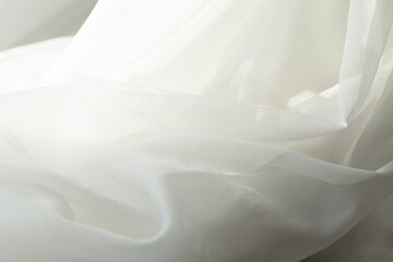 Obraz premium Abstract waves of sheer white fabric, softly illuminated, evoke purity and simplicity. A delicate dance of light and texture.
