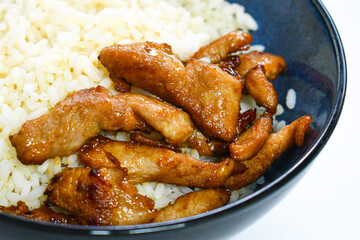 Stir fry pork soy sauce with rice in a bowl.
