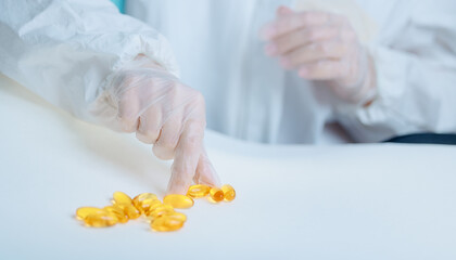 Quality control in omega 3 capsule production by adult technician in lab attire