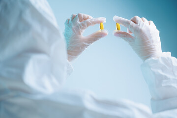 Quality control of omega 3 capsules by medical production worker in protective gear