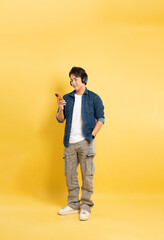 Fototapeta premium Portrait of asian man posing on yellow background.