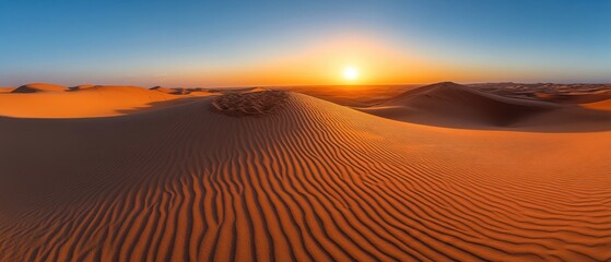 Naklejka premium Majestic desert landscape at sunset with golden sand dunes and clear blue sky creating a serene and peaceful atmosphere in a remote location