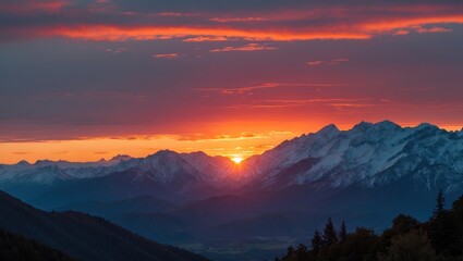 Obraz premium Snow-capped mountains during sunset with dramatic clouds and vibrant orange sky over a valley landscape