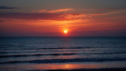 Obraz premium Vibrant sunset over calm ocean waters with colorful clouds reflecting on the surface of the sea during twilight time