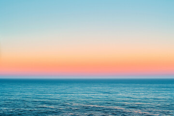 Obraz premium Beautiful sunset over the ocean with colorful sky and gentle waves