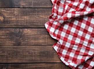 Obraz premium Red checkered tablecloth on rustic wooden background, perfect for cozy dining and inviting atmospheres.