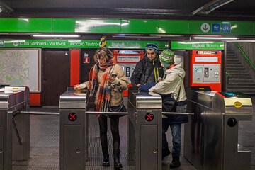 family near the entrance through the turnstiles in the metro Milan in Italy in January 2025. travel...