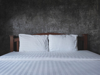 Vintage bedding over grunce concrete wall i bedroom.