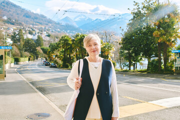 Outdoor portrait of happy middle age woman of 55 - 60 years old, image taken in Montreux, Switzerland