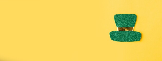 Saint Patrick leprechaun paper hat isolated on bright yellow background. Minimal concept. Copy...