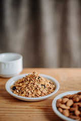 A healthy breakfast scene with granola in a white plate, a glass of water, and a wooden table, perfect for promoting nutrition, wellness, and morning routines.