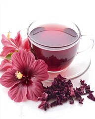 Refreshing hibiscus tea in a glass cup with vibrant red flowers and dried petals on a bright white background