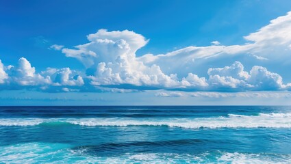 Obraz premium Tranquil Ocean Waves Under Bright Blue Sky with Fluffy White Clouds and Deep Blue Sea Color Perfect for Nature and Travel Themes