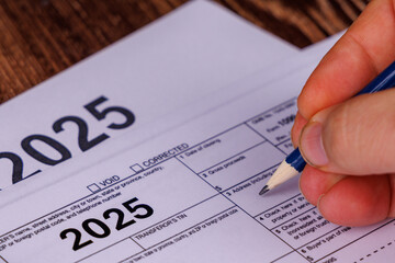 A desk with a calendar circled in red for April 15th, calculators, and pencils, illustrating the steps to complete the 1099 form