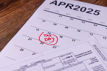 A desk setup with a calendar marked April 15th, calculators, and pencils, illustrating the process of preparing the 1099 form