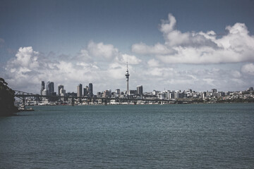 Fototapeta premium Retro style photo of a view over Auckland Harbour and a skyline of Auckland City from a suburb of Birkinhead. North Island, New Zealand