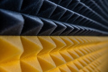 Close-up of black and yellow acoustic foam panels, soundproofing material