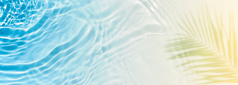 abstract sand beach with blue transparent water wave and palm leaf shadow on sunny tropical background banner, beautiful nature scene with copy space for travel, vacation and beauty spa 