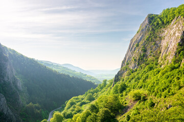 Fototapeta premium mountain landscape of romania in springtime. rock formation and grassy hill in morning light. scenery in valisoarei valley