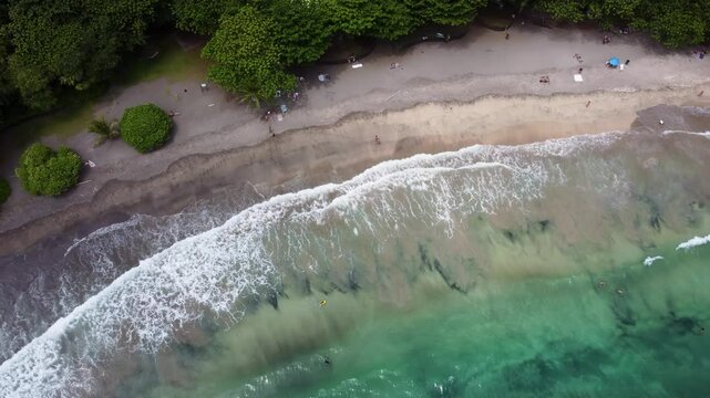 Hamoa Beach Hana Maui Hawaii &ndash; Top down Cinematic aerial video showcasing crystal-clear blue waters, big waves, lush tropical greenery. A breathtaking Maui surf and beach paradise