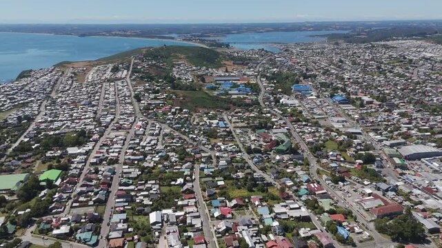 Panoramic aerial view of Ancud city on Chilo&eacute; Island showcasing its urban and coastal areas. dolly back