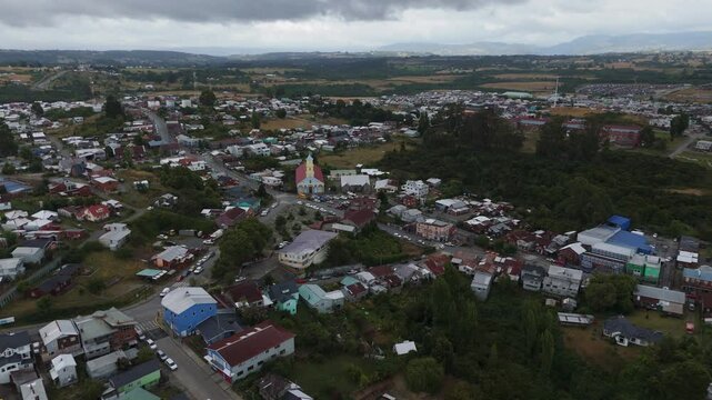 Drone capturing Chonchi, a charming town nestled in the picturesque landscapes of Chiloe Island, showcasing its vibrant architecture and the prominent church. orbit motion