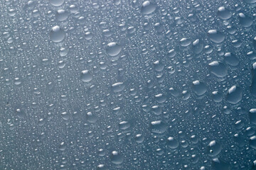 Water drops on light glass surface, top view