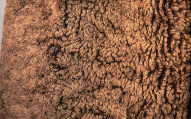 Close-up of a textured brown faux fur fabric.