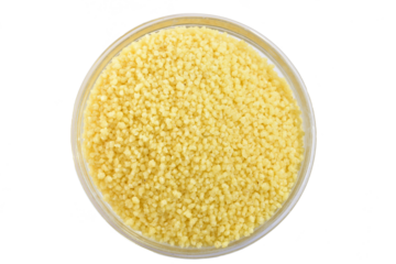 Couscous groats in glass bowl isolated on white background.