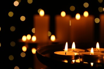 Many burning candles on dark surface, closeup. Space for text