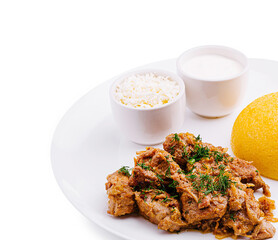 Savory meat dish served with polenta and yogurt on a white plate