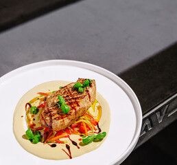 Grilled chicken breast served on creamy sauce with vegetables