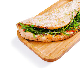 Delicious flatbread filled with fresh greens on a wooden platter