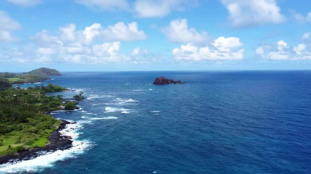 Hamoa Beach Hana Maui Hawaii &ndash; Experience a panoramic cinematic view of this breathtaking Maui beach, featuring crystal-clear waters, rolling waves, lush green cliffs, and volcanic rock formations.