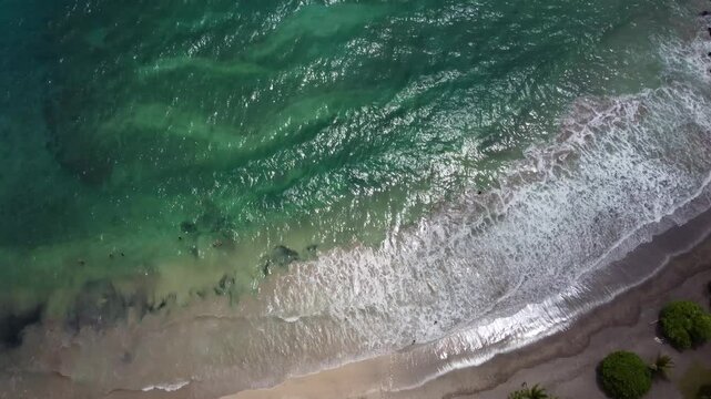 Hamoa Beach Hana Maui Hawaii &ndash; Stunning top-down aerial cinematic video capturing the pristine sandy beach, crystal-clear blue waters, and powerful rolling waves, showcasing beauty of Maui paradise