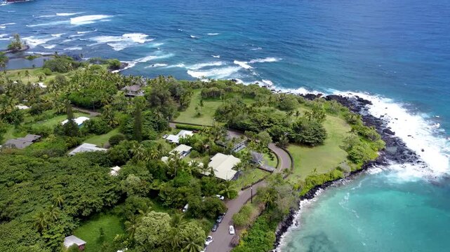 Hamoa Beach Hana Maui Hawaii &ndash; Cinematic high-altitude aerial video of stunning blue waters, waves, lush green landscapes, Hana Highway, Haneoo Road, and dense tropical trees along the coastline