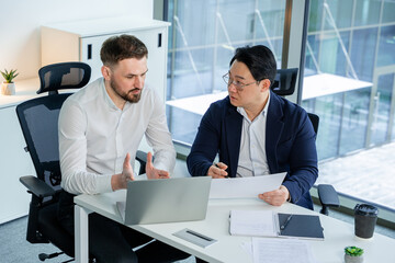 Successful business professionals actively discussing work projects in a modern office setting....