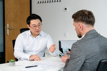 Professional business interaction with two males in a modern office, focusing on finance and consultation, showcasing professionalism and collaborative efforts.
