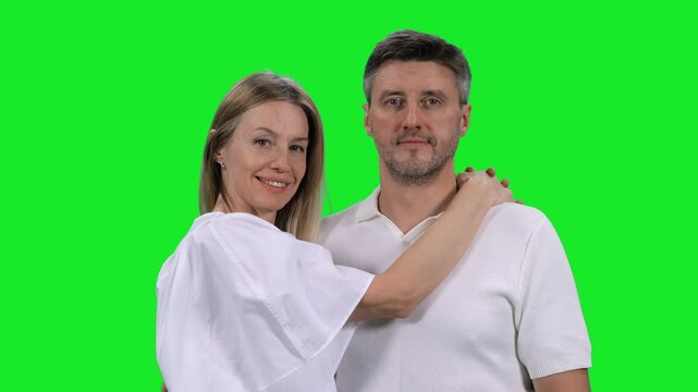 Portrait of adult loving couple looking at camera on green chroma key background, 4k pre-keyed footage
