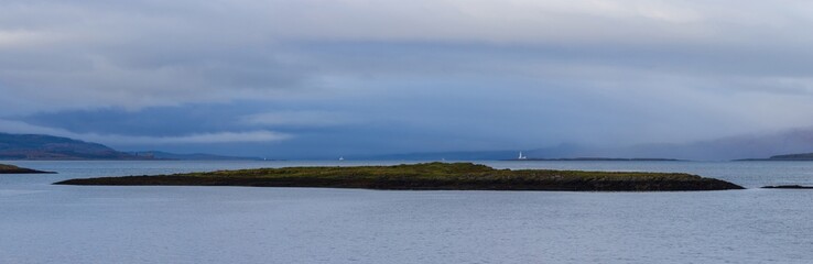 Panoramic image of a tiny island off the coast of Kerrera with the Isle of Mull in the distance, Inner Hebrides, Scotland, UK.