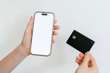 Woman hands holding credit card and blank phone screen