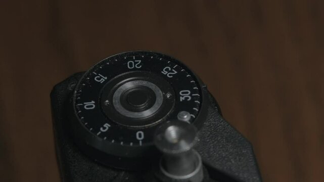 Macro close-up of a film rewind clock on an analog camera