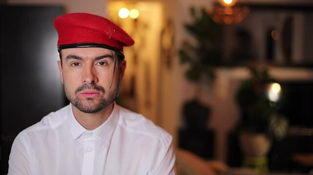 Smiling Man Wearing a Red Military Style Beret with Communist Symbol Pin