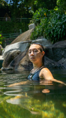 Fototapeta premium Mujer relajada flontando en medio del agua de la piscina natural