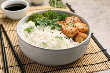 Tasty rice with broccoli and chicken served on grey table, closeup