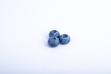 Close-up of three fresh blueberries isolated on a clean white background. The berries are plump and ripe, showcasing their natural blue hue and texture, ideal for healthy snacks, desserts